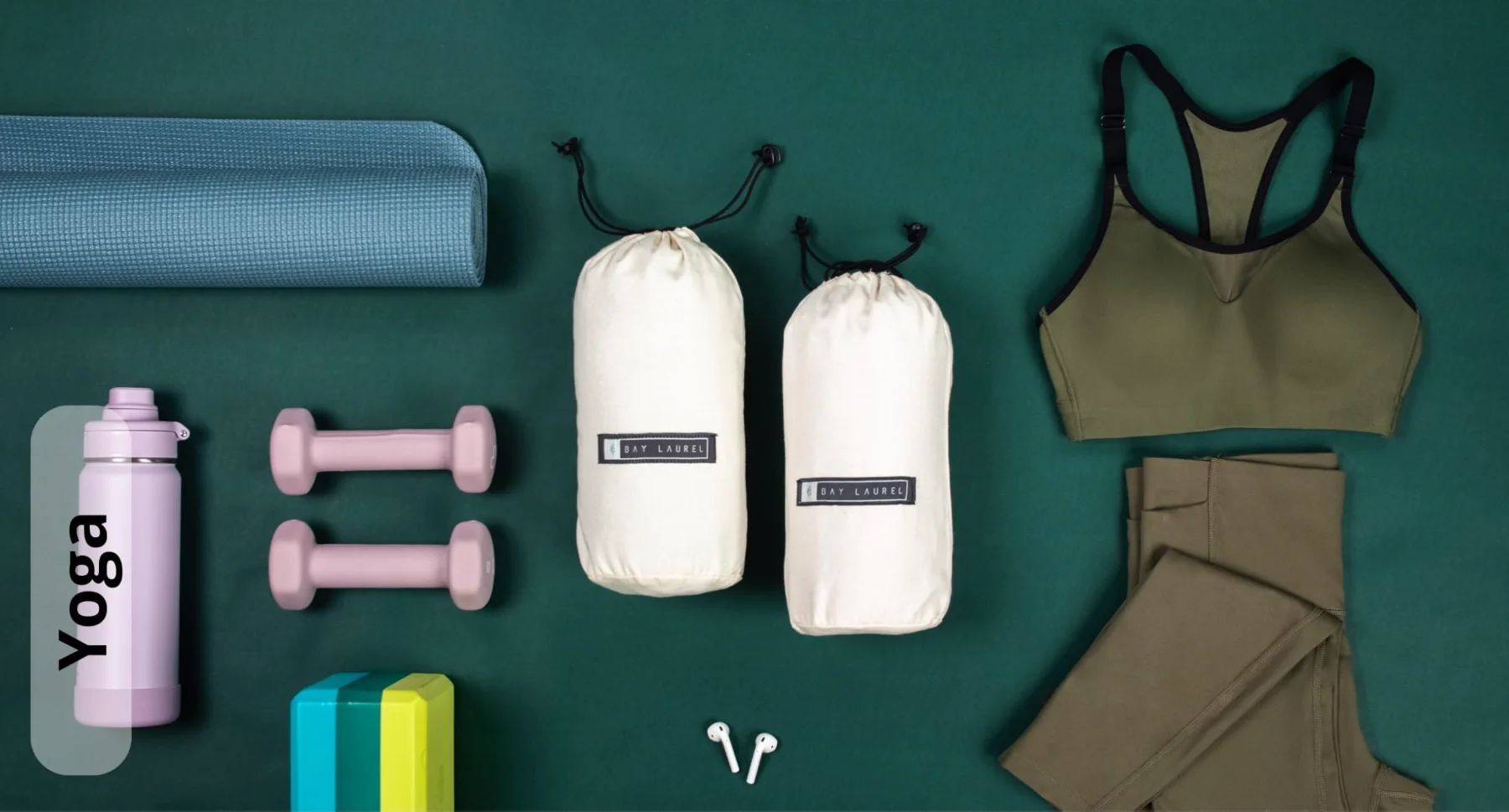 Two rolled towels in their bags flat-laid with yoga kit